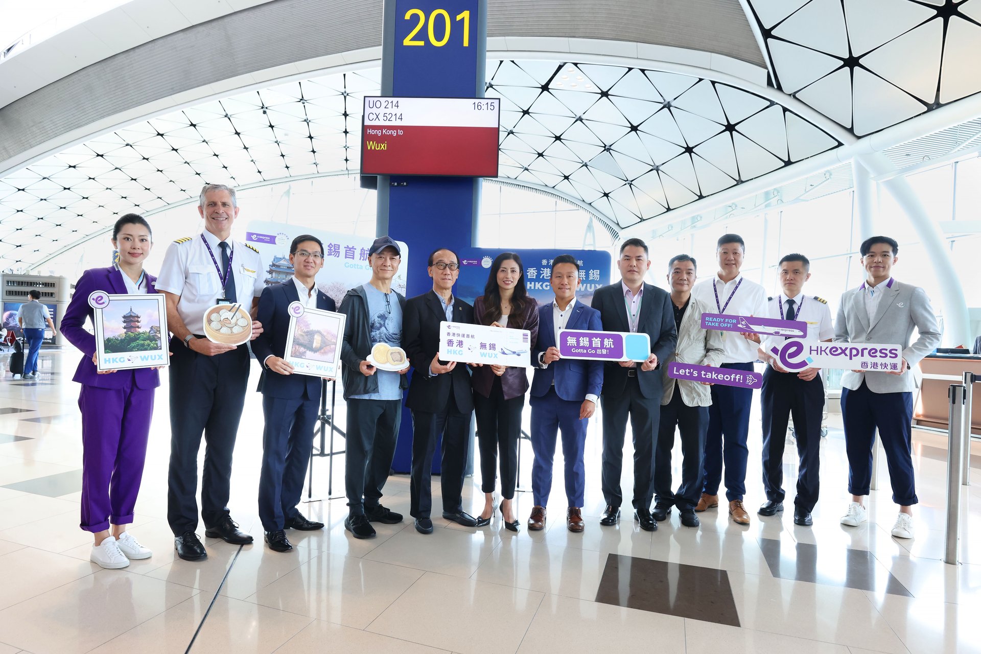 香港快运航空行政总裁毛洁琼（中）丶香港旅游业议会主席谭光舜（左五）丶香港文化体育及旅游局旅游事务助理专员梁进曦（右六）丶香港旅游业监管局监管事务总监张嘉贤（左四）丶香港机场管理局航空网络发展总经理庄伟褀（右五）及香港快运管理层与机组人员于香港国际机场出席庆祝新航线启航仪式。 