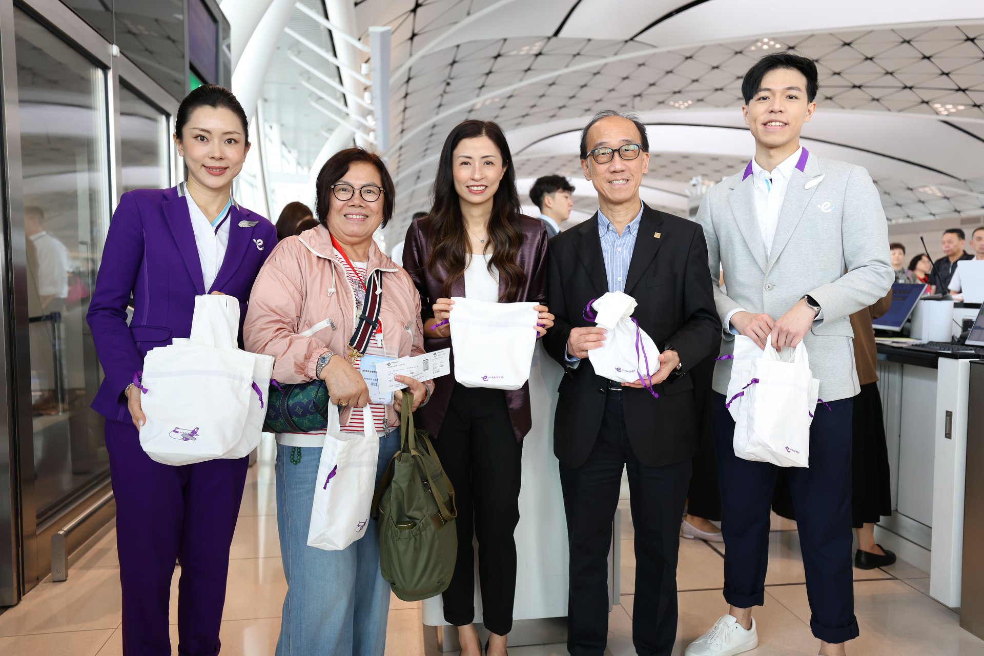 香港快运管理层团队在香港国际机场与旅客合照及派发纪念品，庆祝香港快运香港—无锡航线首航。 